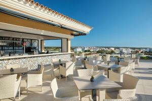 a patio with tables and chairs and a bar at Grupotel Playa de Palma Suites & Spa in Playa de Palma