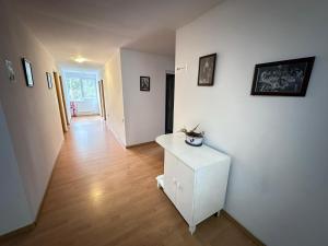a hallway with white walls and a white cabinet at Motel Valea Zanelor in Covasna