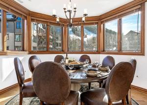 a dining room with a table and chairs and windows at 323 Beaver Creek Lodge in Avon