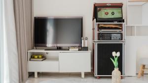 a living room with a flat screen tv and a entertainment center at Ganghwa Glory Bada Pension in Incheon