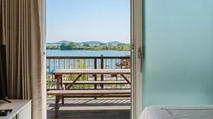 a room with a door open to a balcony with a bench at Ganghwa Glory Bada Pension in Incheon +5 photos