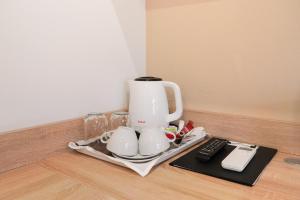 a coffee maker and cups on a tray on a counter at Erhardt Superior Rooms in Sopron