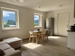 eine Küche und ein Wohnzimmer mit einem Tisch und einem Kühlschrank in der Unterkunft Feder Peaks in Canale dʼAgordo