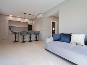 a living room with a white couch and a kitchen at Airport Split in Kastel Stafilic