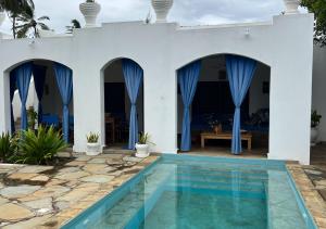 a villa with a swimming pool and a house at Villa Rita in Gede