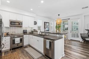 a kitchen with white cabinets and stainless steel appliances at Sea Glass Villa in Oceanside