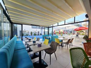 a restaurant with blue chairs and tables and windows at Bunga Bunga Resort Mamaia Nord in Mamaia Sat/Năvodari