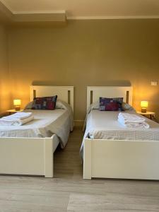 a bedroom with two beds and two lamps at Spacious e Modern Comfort Near Center in Lucca