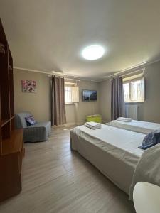 a large bedroom with two beds and a couch at Spacious e Modern Comfort Near Center in Lucca