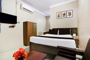 a hotel room with a bed and a table at Super Collection O NIT More Adityapur Formerly Hotel Subheksha in Jamshedpur +24 photos