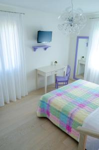 a bedroom with a bed and a desk and a tv at Alloggi Agrituristici Le Vignole in Cordignano