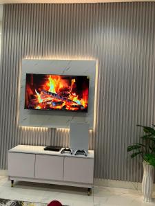 a living room with a tv on a wall at Blu in Ikeja