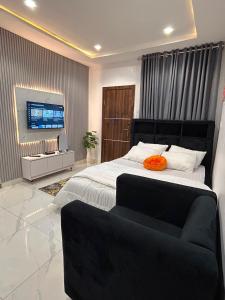 a bedroom with a large bed and a flat screen tv at Blu in Ikeja