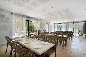 a dining room with tables and chairs and windows at 15.La colline Clim.option- 6 pers in Calviac