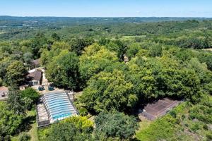 an overhead view of a pool in the trees at 15.La colline Clim.option- 6 pers in Calviac