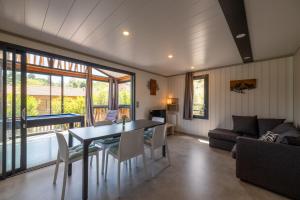 a dining room with a table and chairs and a couch at Chalet L'entékia - Billard et Spa in Corcieux