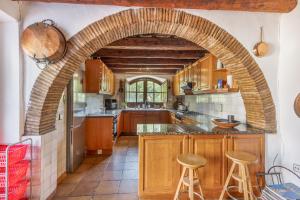 an archway in a kitchen with wooden cabinets at Apartamento I Els Cucons in Sant Pere de Ribes