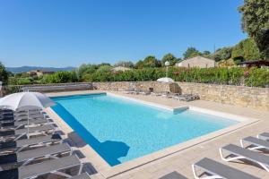 a pool with chaise lounge chairs and a swimming pool at Le Peuplier - La Fontinelle in Bessas