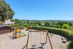 a playground with a swing set in a yard at Le Peuplier - La Fontinelle in Bessas
