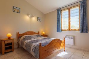a bedroom with a wooden bed and a window at Le Peuplier - La Fontinelle in Bessas +24 photos