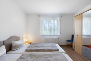 a white bedroom with a bed and a window at Apartment 44 in Bad Dürrheim