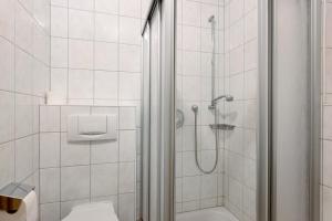a white bathroom with a shower and a toilet at Apartment 45 in Bad Dürrheim +13 photos