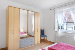a bedroom with a large wooden cabinet with a blue chair at Apartment 45 in Bad Dürrheim