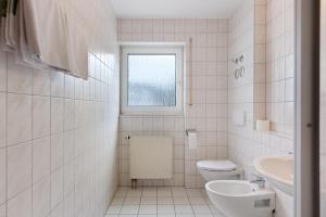 a white bathroom with a toilet and a sink at Apartment 30 in Bad Dürrheim +13 photos