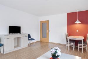 a living room with a television and a table with chairs at Apartment 30 in Bad Dürrheim