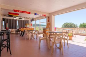 a dining room with tables and chairs and a patio at Le Micocoulier - La Fontinelle in Bessas