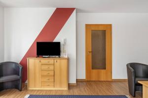 a room with a tv on a dresser and a door at Apartment 47 in Bad Dürrheim