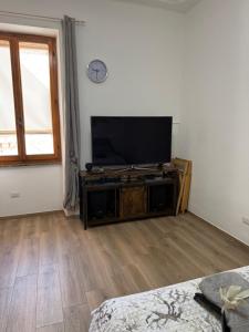 a living room with a flat screen tv on a stand at Sa Domitta due Alghero in Alghero