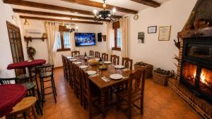 a dining room with a long table and a fireplace at Casa Rural Raíces del Alto Tajo in Armallones