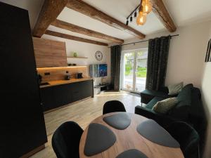 a living room with a table and a kitchen at Agroturystyka u Iwony in Wiekowo