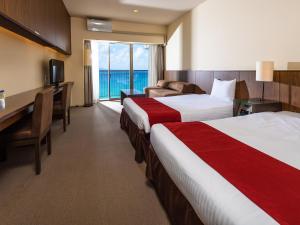 a hotel room with two beds and a desk at Hotel Resonex Nago in Nago
