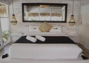 a bedroom with a large white bed with two pillows at White Palm Uluwatu - Wellness & Recovery Retreat - 2 Min Walk to Balangan Beach in Jimbaran +85 photos