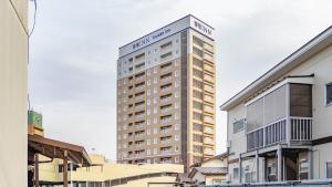 a tall building with a sign on top of it at Toyoko Inn Kitakami-eki Nishi-guchi in Kitakami
