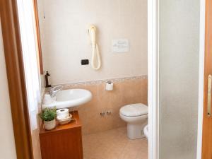 a bathroom with a toilet and a sink and a phone at Le Camere DI Lucia Affittacamere in Colà di Lazise