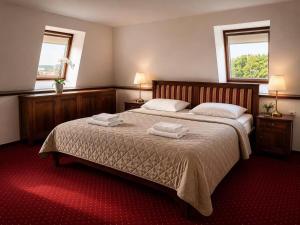 a bedroom with a large bed with two towels on it at Hotel ZÁMOCKÁ KORUNA u Hoffera in Nitra