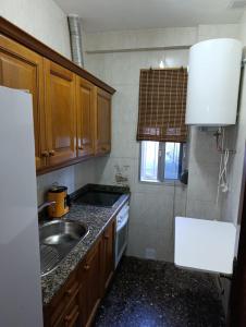 a small kitchen with a sink and a stove at Alojamiento Rural La Granja in La Cerradura +16 photos
