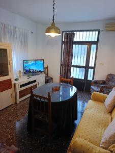 a living room with a table and a tv at Alojamiento Rural La Granja in La Cerradura