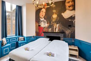 a room with two beds in front of a painting at Stayokay Hostel Domburg in Oostkapelle