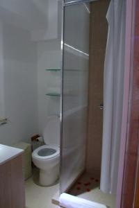 a bathroom with a toilet and a glass shower at Bora Dormir in Lagos