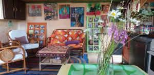 a room with a couch and chairs and pictures on the wall at Cabane Layénie sous les étoiles in Bajamont
