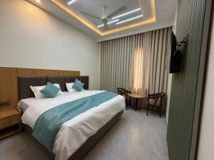 a bedroom with a large bed with blue pillows at Hotel Kanta Kuteer Barsana in Barsāna
