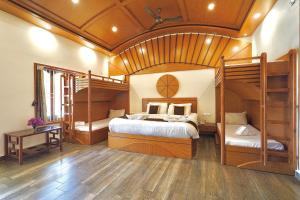 a bedroom with two bunk beds and a wooden ceiling at Singaras Coffee Country in Masinagudi