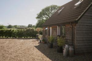 a small house with potted plants in front of it at Coach House in Milton Keynes