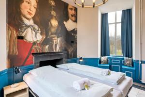 two beds in a room with a painting on the wall at Stayokay Hostel Domburg in Oostkapelle