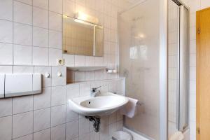 a white bathroom with a sink and a mirror at Apartment 36 in Bad Dürrheim +15 photos