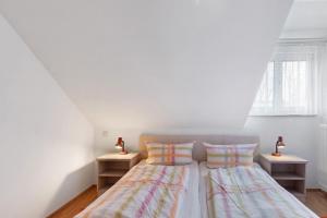 two beds in a white room with two lamps at Apartment 36 in Bad Dürrheim